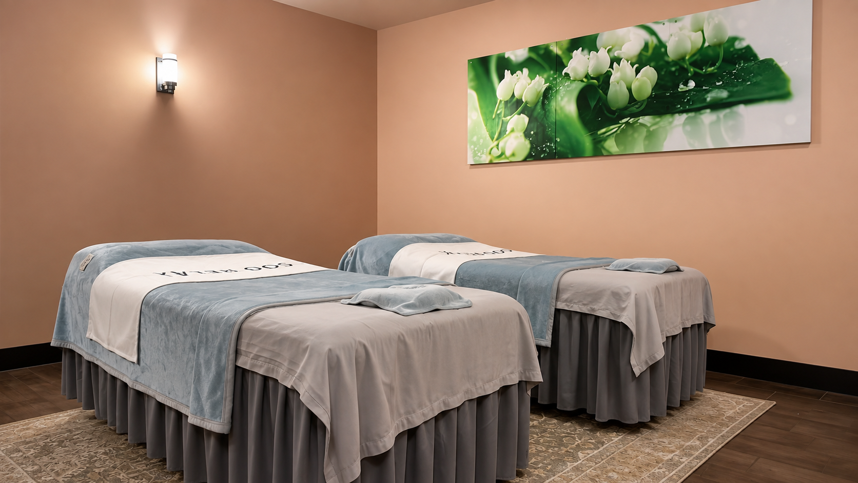 Massage room with two treatment beds and floral wall art